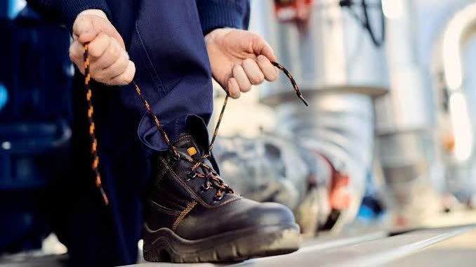 Trabalhador calçando bota de segurança: cuidado podológico para quem usa EPI