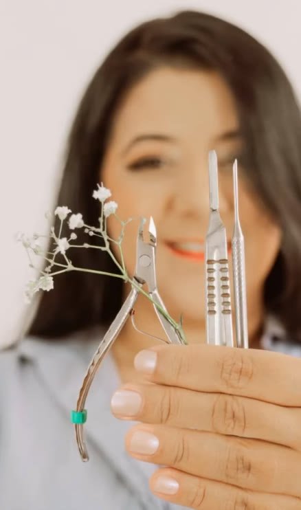 Cássia Vieira, podóloga da Acássia Podologia, segurando instrumentos esterilizados e uma flor