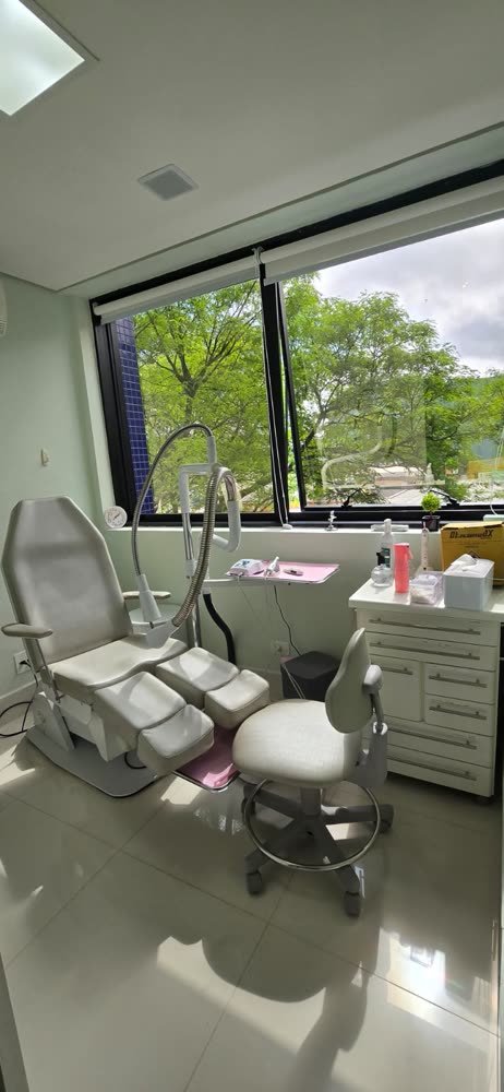 Sala de atendimento de podologia com vista para as árvores